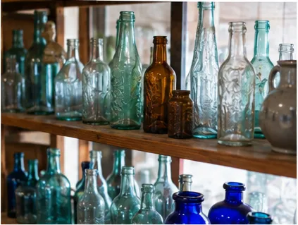Shelves lined with vintage colored glass bottles
